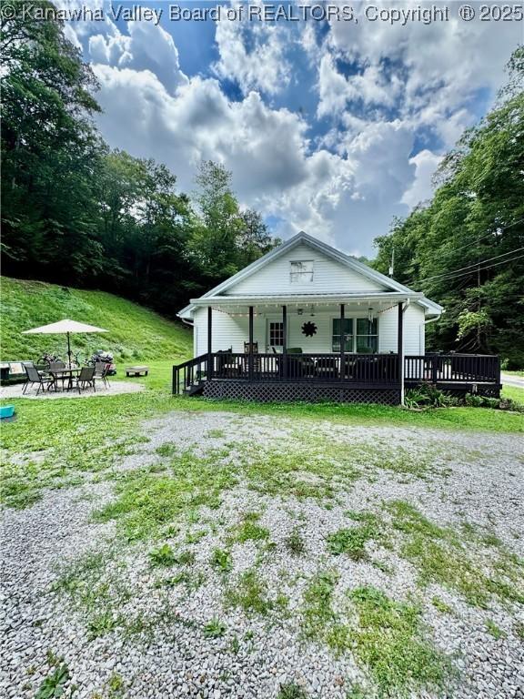 28 Brushy Frk, Alkol, WV 25501 - view of front of property with an outdoor fire pit, a front lawn, and a deck