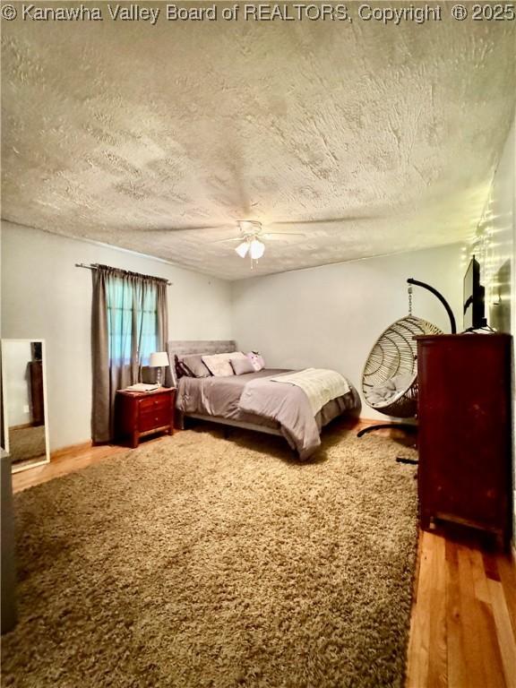 28 Brushy Frk, Alkol, WV 25501 - bedroom featuring wood finished floors, a textured ceiling, and a ceiling fan