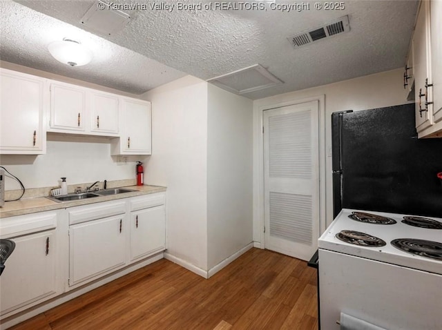 105 Lincoln Hts, Alum Creek, WV 25003 - kitchen with white electric range, light wood-type flooring, white cabinets, a textured ceiling, and light countertops