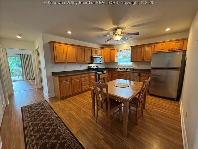 2314 Harrison Ave, Saint Albans, WV 25177 - kitchen featuring stainless steel appliances, dark countertops, brown cabinets, ceiling fan, and light wood finished floors