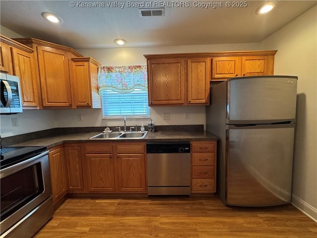 2314 Harrison Ave, Saint Albans, WV 25177 - kitchen with appliances with stainless steel finishes, dark countertops, brown cabinets, wood finished floors, and recessed lighting