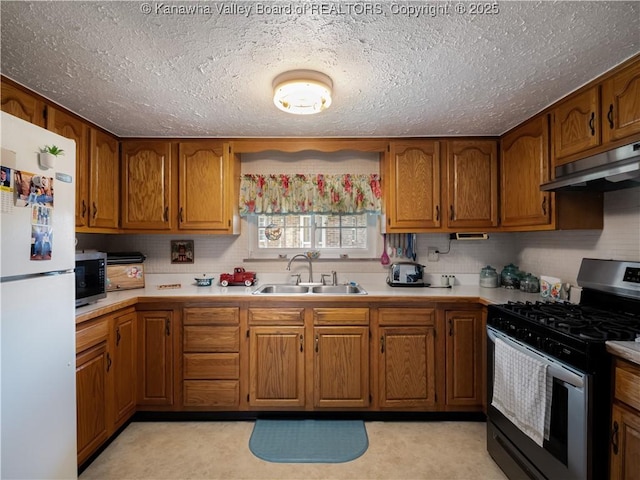 4728 Cain Ridge Rd, Leon, WV 25123 - kitchen with appliances with stainless steel finishes, brown cabinetry, light countertops, under cabinet range hood, and a textured ceiling