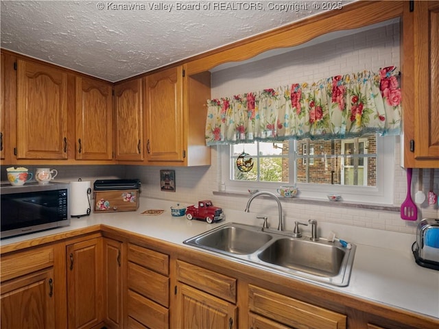 4728 Cain Ridge Rd, Leon, WV 25123 - kitchen with stainless steel microwave, brown cabinets, a textured ceiling, light countertops, and backsplash