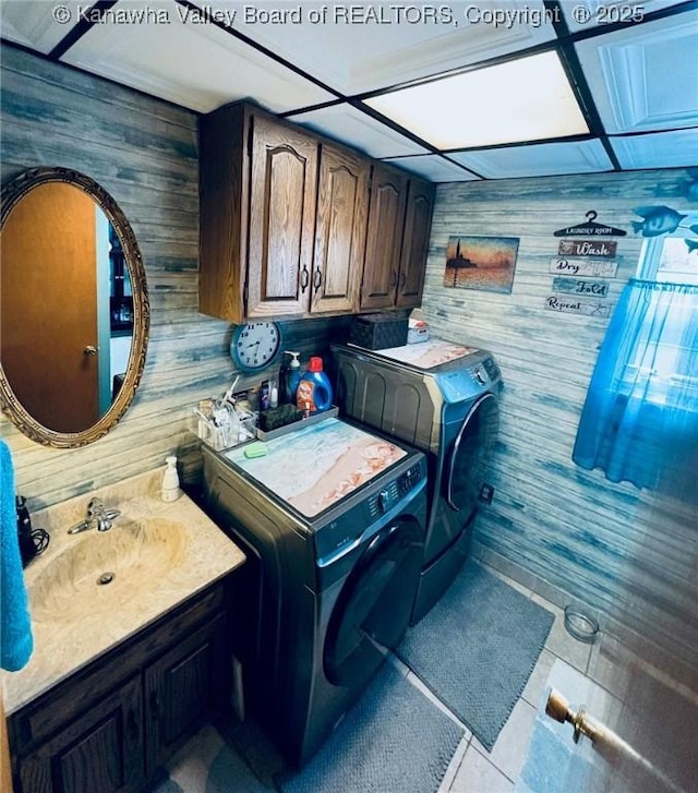 1816 Winding Hill Dr, Sissonville, WV 25320 - washroom featuring wooden walls, separate washer and dryer, tile patterned flooring, and cabinet space