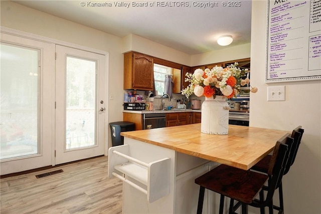 51 Beaver Dr, Hurricane, WV 25526 - kitchen featuring a kitchen breakfast bar, brown cabinetry, light wood-style floors, butcher block counters, and dishwashing machine