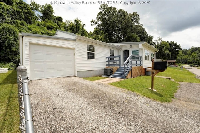 1009 Midway Dr, Dunbar, WV 25064 - view of front facade with an attached garage, a front yard, asphalt driveway, and view of wooded area
