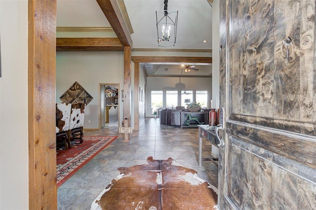 entrance foyer featuring beamed ceiling, ceiling fan with notable chandelier, and ornamental molding