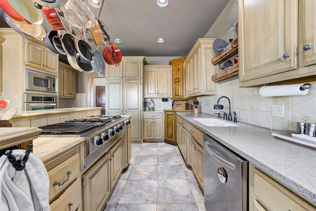 kitchen featuring sink, light brown cabinets, decorative backsplash, light tile patterned floors, and appliances with stainless steel finishes