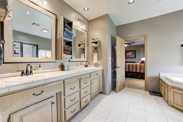 bathroom with tile patterned floors, ceiling fan, a bathing tub, and vanity