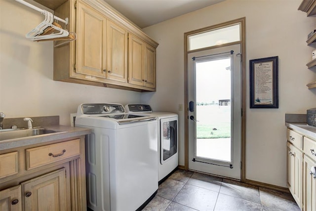 laundry room featuring washer and clothes dryer, cabinets, light tile patterned floors, and sink