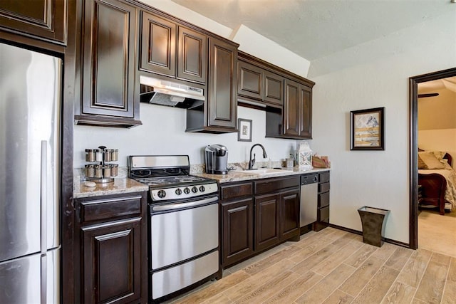 kitchen featuring sink, dark brown cabinetry, stainless steel appliances, and light hardwood / wood-style flooring