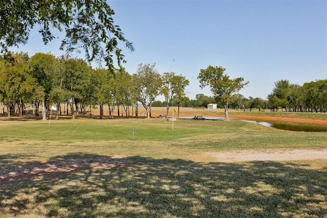 surrounding community featuring a water view and a lawn