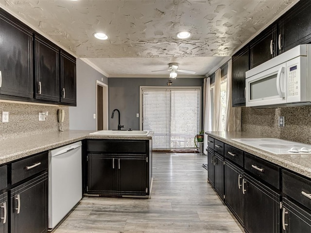 kitchen featuring ceiling fan, sink, white appliances, decorative backsplash, and light wood-type flooring