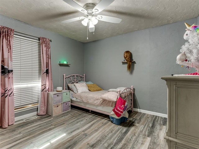 bedroom featuring a textured ceiling, light hardwood / wood-style flooring, and ceiling fan