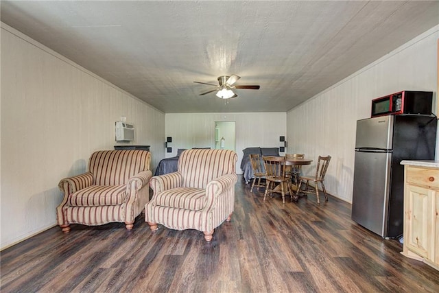 sitting room with a wall unit AC, ceiling fan, and dark hardwood / wood-style flooring