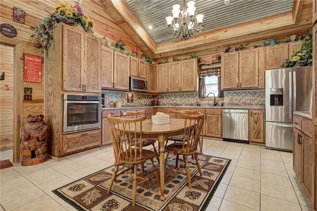 304 W Oak St, Canton, OK 73724 - kitchen with appliances with stainless steel finishes, a chandelier, light tile patterned flooring, tasteful backsplash, and vaulted ceiling