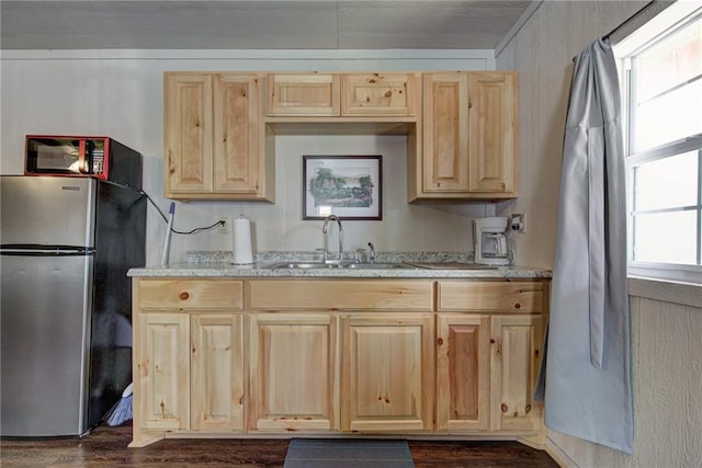 kitchen featuring light brown cabinets, dark wood-type flooring, sink, stainless steel fridge, and light stone countertops