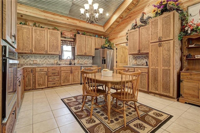 304 W Oak St, Canton, OK 73724 - kitchen with appliances with stainless steel finishes, vaulted ceiling, a chandelier, decorative backsplash, and light tile patterned floors