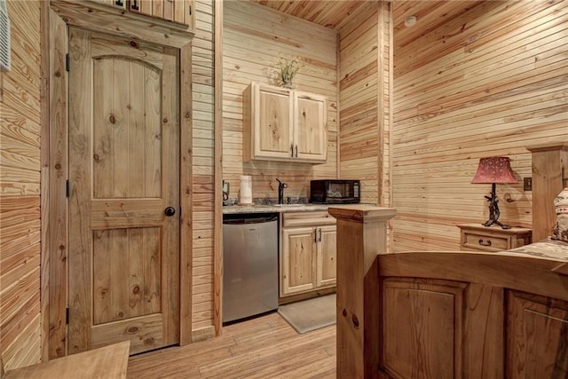 kitchen with stainless steel fridge, wooden walls, light brown cabinetry, and light wood-type flooring