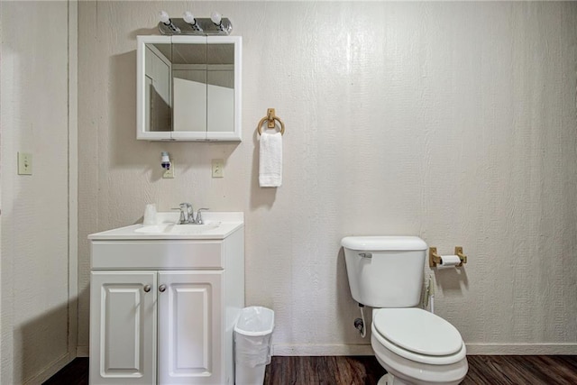 bathroom featuring toilet, vanity, and hardwood / wood-style flooring