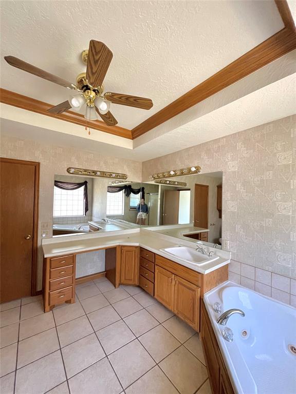 bathroom with vanity, a textured ceiling, a tub to relax in, and tile patterned floors