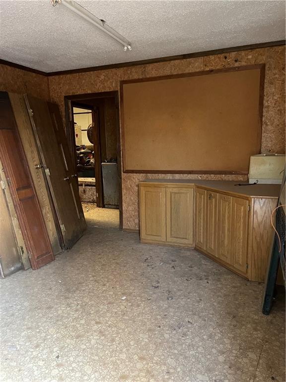 interior space featuring crown molding and a textured ceiling