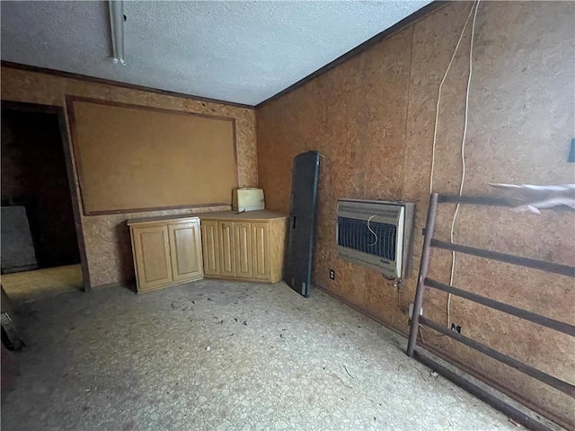 interior space featuring heating unit and a textured ceiling