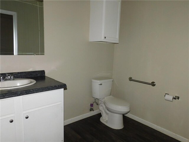 bathroom with hardwood / wood-style floors, vanity, and toilet