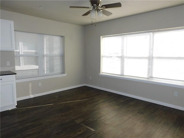 unfurnished dining area featuring ceiling fan and dark wood-type flooring