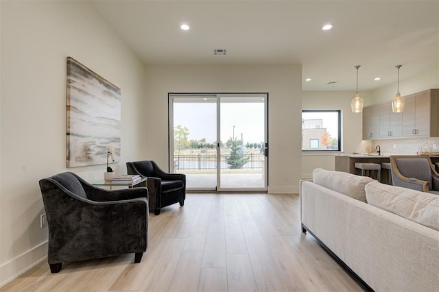 living room with sink and light wood-type flooring