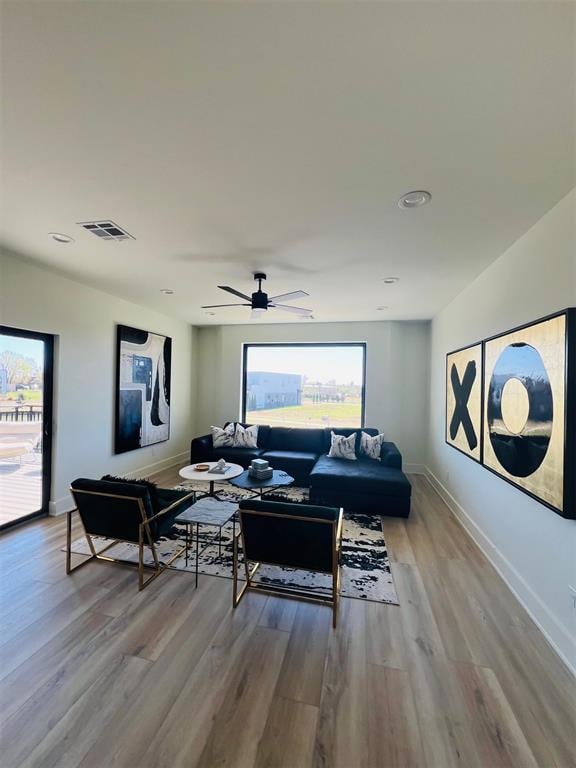 living room with ceiling fan and light wood-type flooring