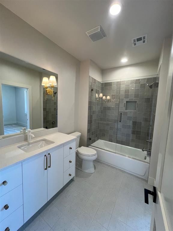 full bathroom featuring shower / bath combination with glass door, vanity, and toilet