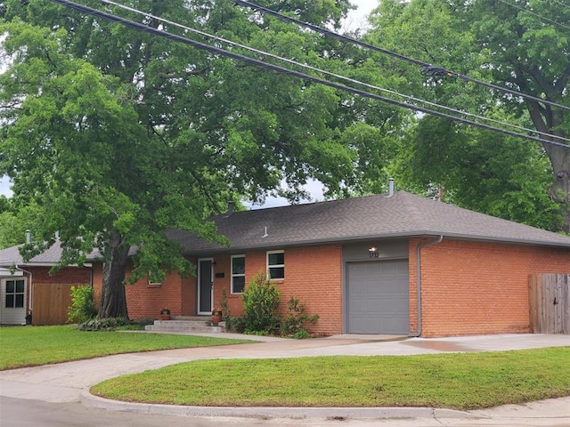 ranch-style home featuring fence, an attached garage, brick siding, concrete driveway, and a front yard