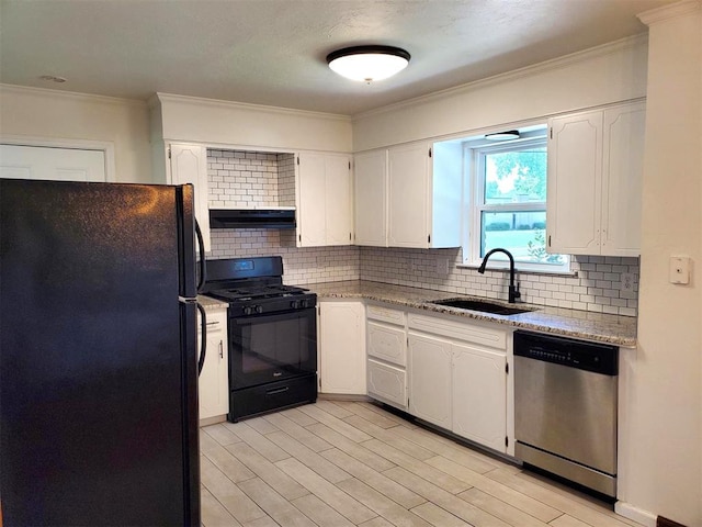 kitchen with a sink, white cabinetry, black appliances, under cabinet range hood, and ornamental molding