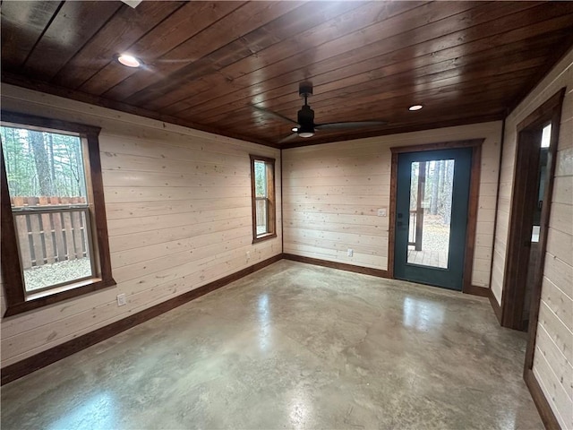 spare room with concrete floors, a wealth of natural light, and wood ceiling