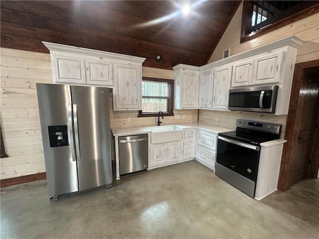 kitchen with stainless steel appliances, vaulted ceiling, white cabinetry, and sink