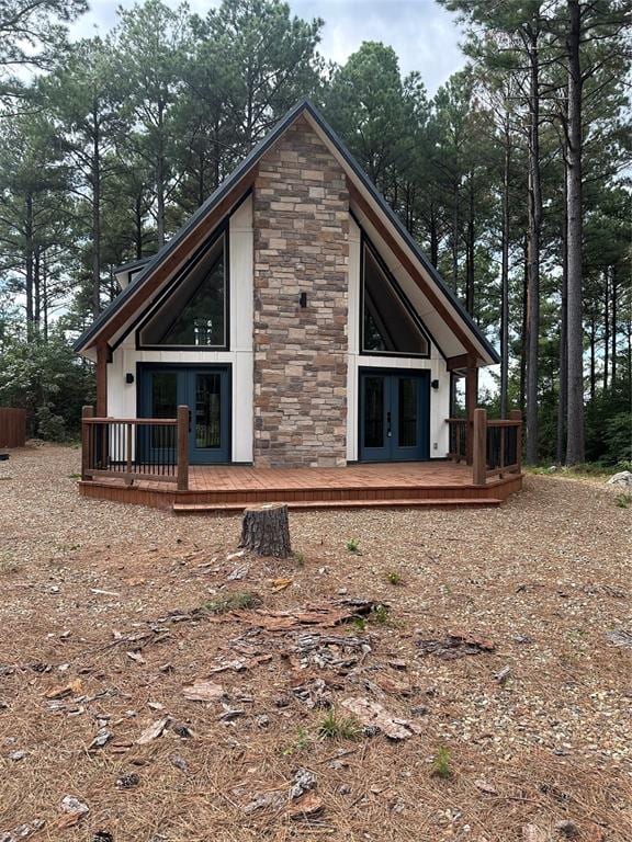 back of house with a wooden deck and french doors