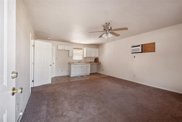 unfurnished living room with a wall mounted AC, light carpet, sink, and ceiling fan