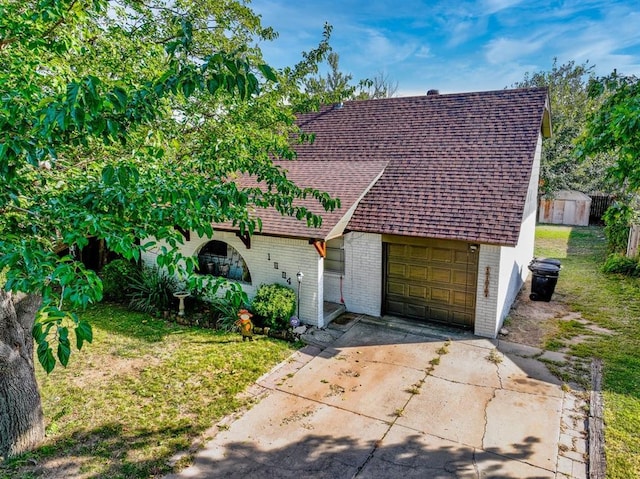 view of front of home featuring a storage unit, a garage, and a front yard