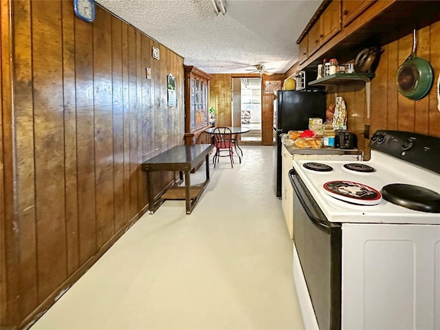 kitchen with ceiling fan, white appliances, a textured ceiling, and wooden walls