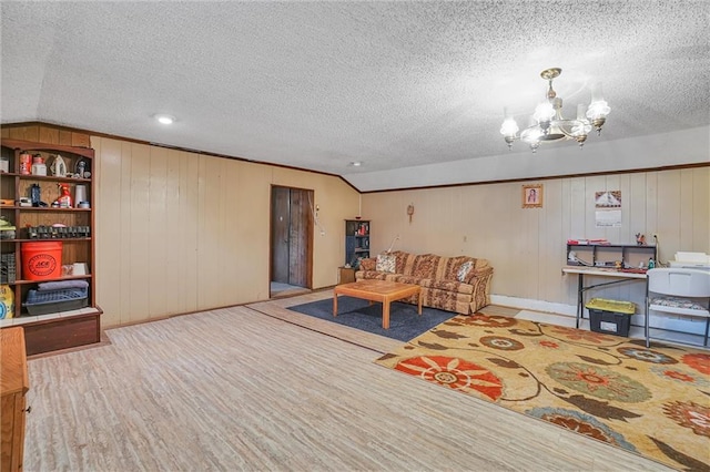 living room with lofted ceiling, wooden walls, a textured ceiling, wood-type flooring, and a chandelier