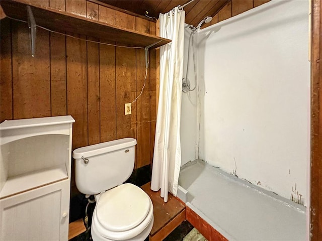 bathroom featuring curtained shower, wood walls, and toilet