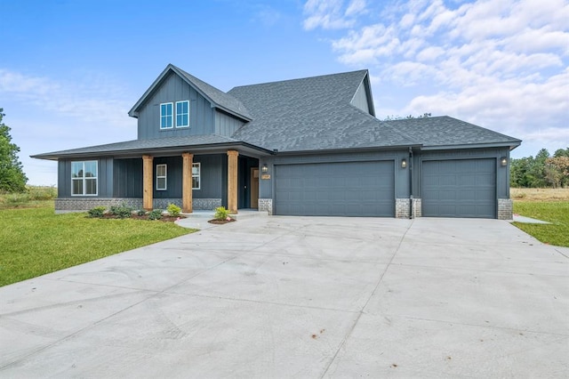 view of front of home featuring a front yard, a garage, and covered porch