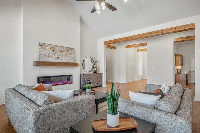 living room with hardwood / wood-style floors, ceiling fan, and vaulted ceiling