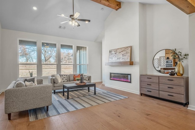 living room featuring ceiling fan, beam ceiling, high vaulted ceiling, and light hardwood / wood-style flooring