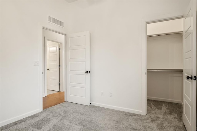 unfurnished bedroom featuring a closet and light colored carpet