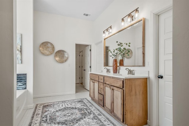 bathroom featuring vanity, a tub to relax in, and tile patterned floors