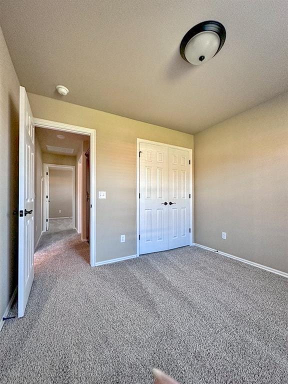 unfurnished bedroom featuring carpet flooring, a closet, and a textured ceiling