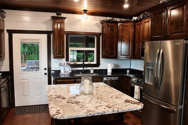 kitchen with stainless steel appliances, dark hardwood / wood-style flooring, dark stone counters, a kitchen island, and wood ceiling