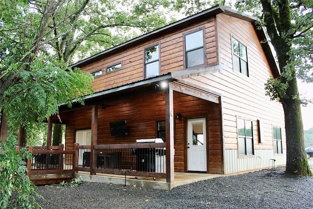 back of property featuring covered porch